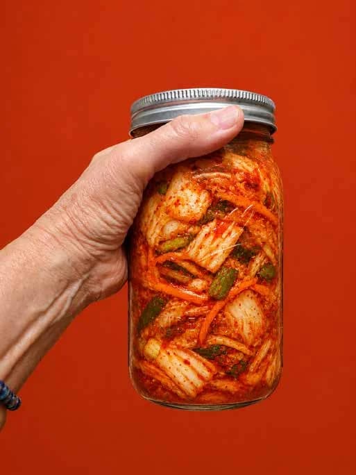 Frasco de kimchi sostenido en la mano